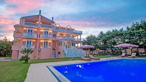 Une grande maison à plusieurs étages, dotée d’une piscine, d’un espace extérieur aménagé et d’un jardin bien entretenu.