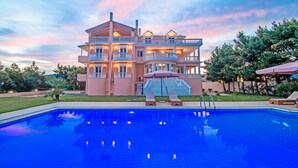Un grand immeuble à plusieurs étages, avec une piscine située devant.