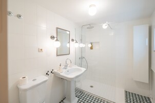 Un baño con inodoro, lavamanos y ducha.