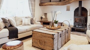 Una sala de estar acogedora con un sofá, una mesa de centro de madera y una chimenea.