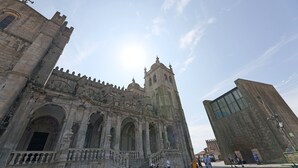 A historic building with a prominent tower and arched windows. - FLH Boavista Flat I (Oporto)