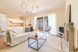 Ein modernes Wohnzimmer mit einem weißen Sofa, einem blauen Couchtisch und einer TV-Konsole.