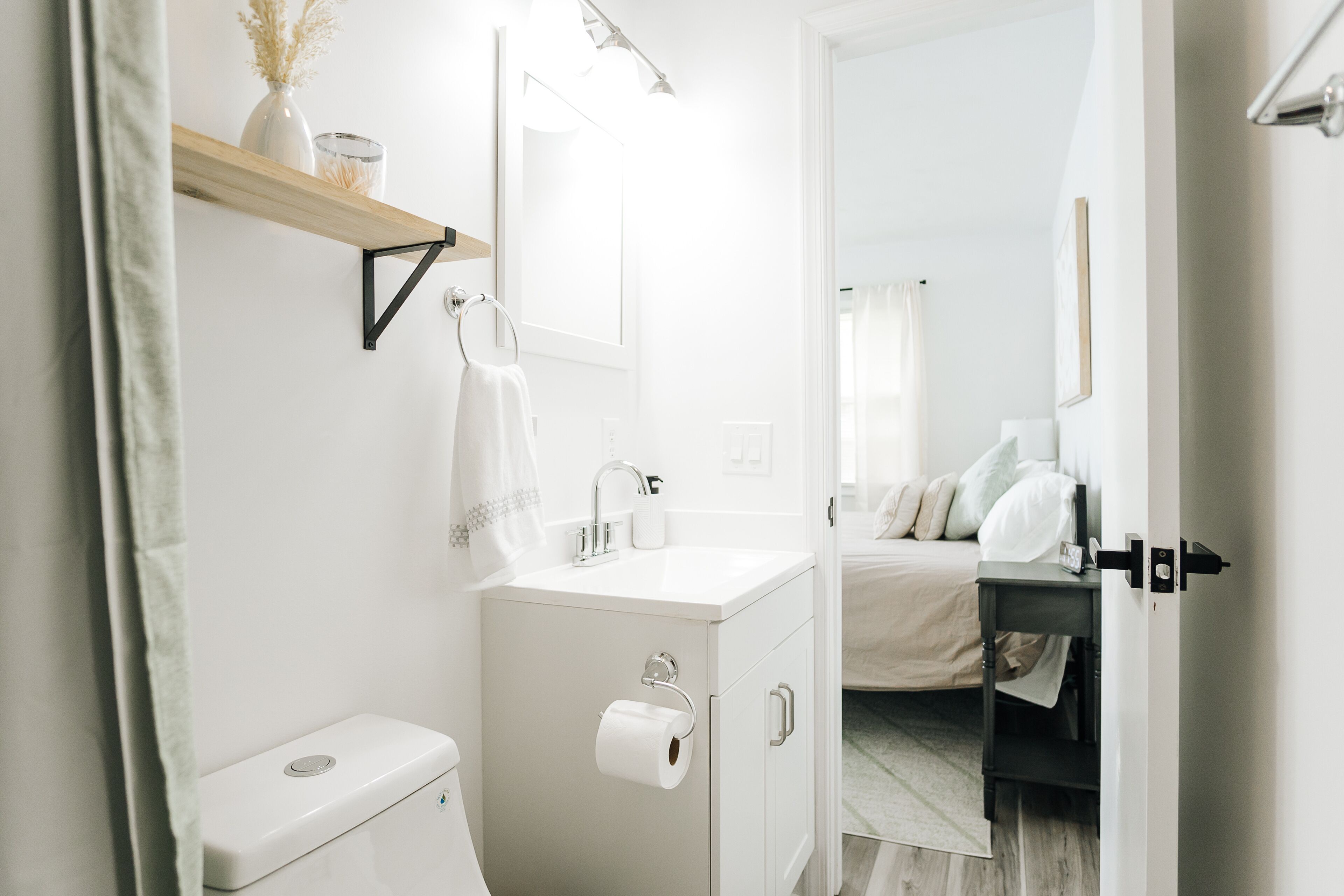 A modern bathroom with a toilet, sink, and mirror.