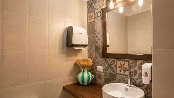 Un baño con inodoro, lavabo y espejo.