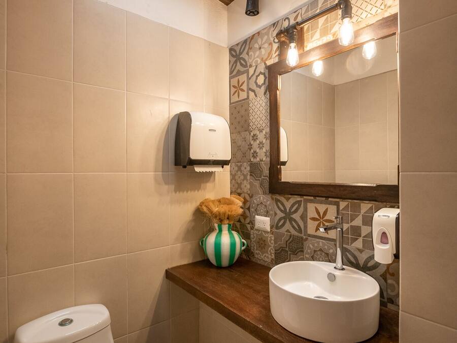 Un baño con inodoro, lavabo y espejo.
