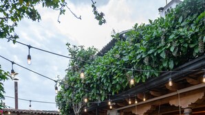 A courtyard with outdoor seating, string lights, and lush greenery.