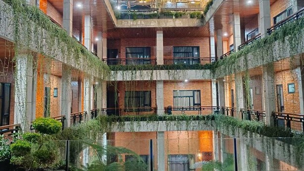 A modern building with a central courtyard featuring a reflective pool. - Pariban Hotel (Berastagi)