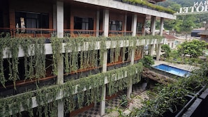 A multi-story building with a rooftop garden and a pool. - Pariban Hotel (Berastagi)
