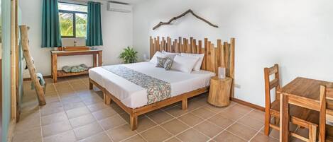 Une chambre avec un lit en bois, une table de chevet, une chaise et une fenêtre avec des rideaux.