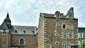 A historic stone building with multiple windows and a prominent tower.