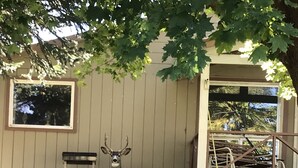 A deer statue in front of a building with a porch and steps leading up to it. - Cozy country farmhouse (Prairie City)