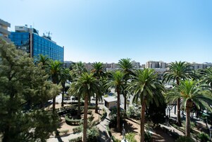 Blick auf eine Stadtlandschaft mit Palmen und einem blauen Gebäude im Hintergrund.
