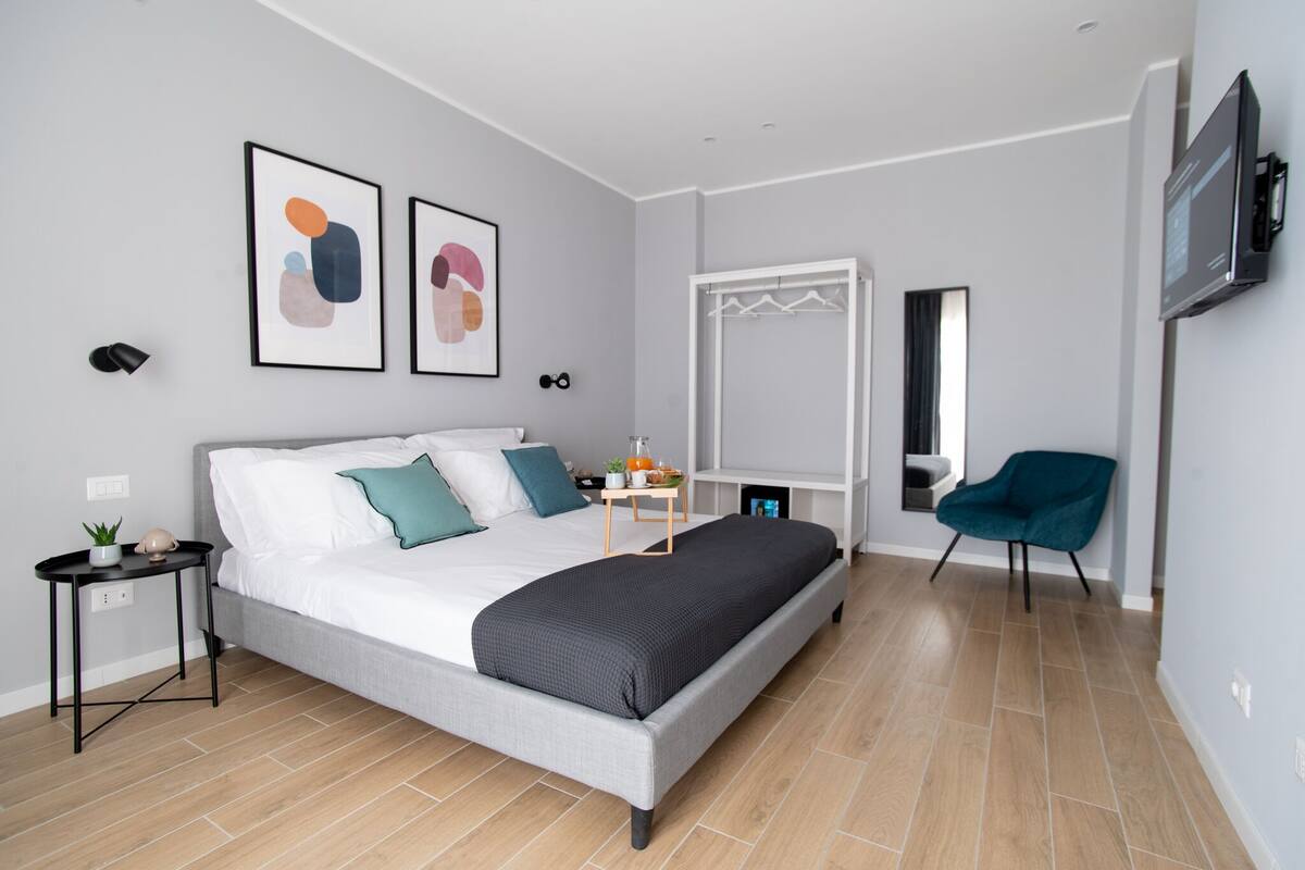 Een moderne slaapkamer met een bed, nachtkastje en een stoel.