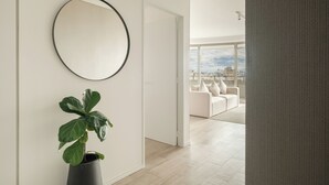 A modern living room with a large window, a round mirror, and a potted plant. - Nido x Recoleta Deco (Buenos Aires)