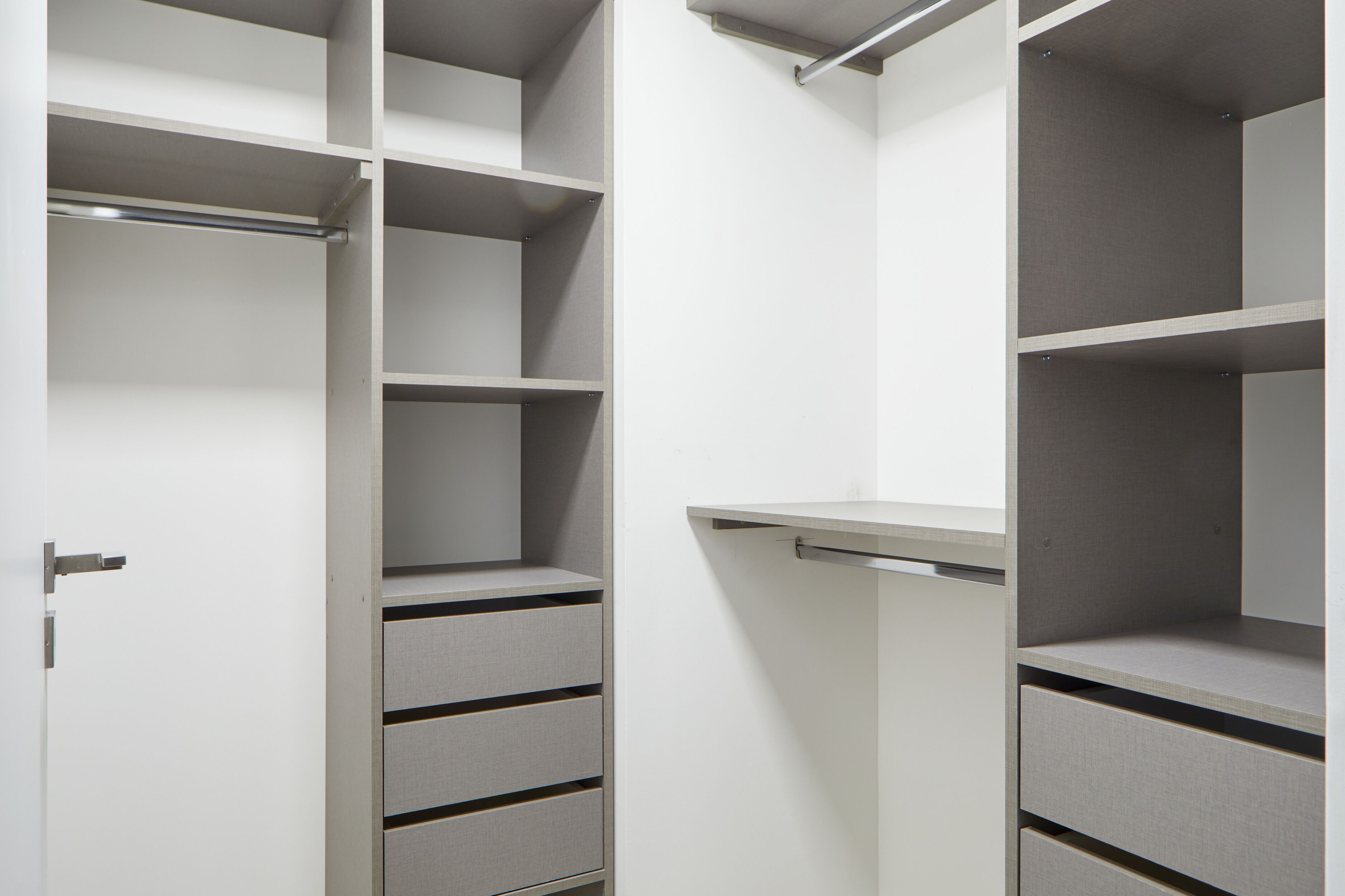 A walk-in closet with open shelves and drawers.