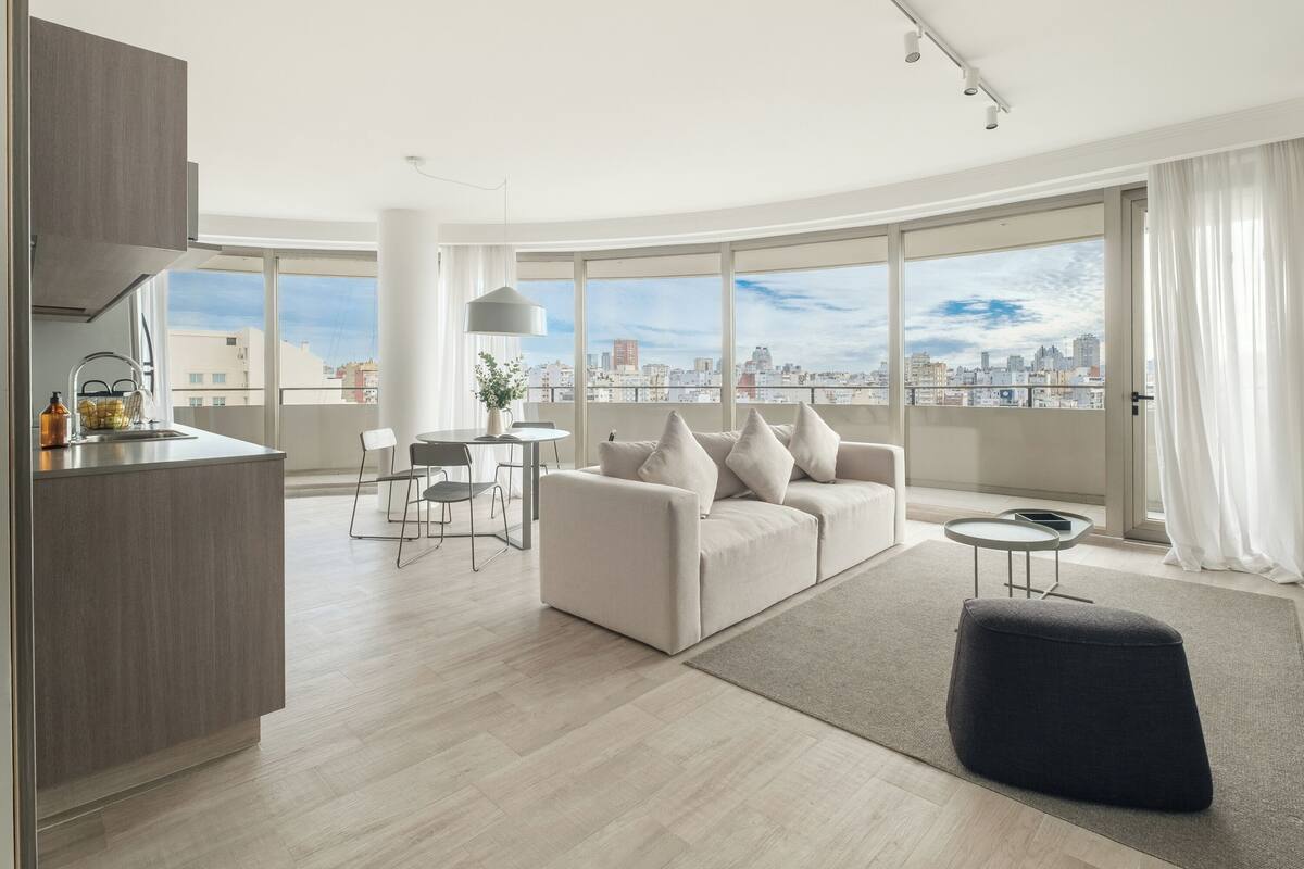 Una sala de estar moderna con un sofá, una mesa de comedor y una zona de cocina.