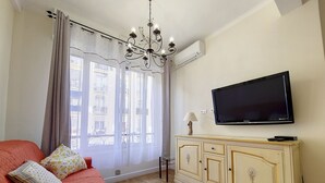 Ein Wohnzimmer mit einer Couch, einem Fernseher und einem Schrank.