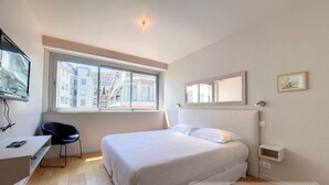 A bedroom with a bed, a desk, a chair, a window, and a mirror. - N&J - FLEURS TERRASSE - 3 bedrooms (Niza)