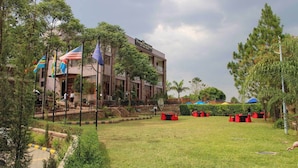 A hotel with a modern design, featuring a two-story structure and a well-maintained lawn with outdoor seating.
