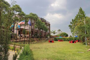 Un hotel de diseño moderno, con una estructura de dos plantas y un césped bien cuidado con mesas al aire libre.