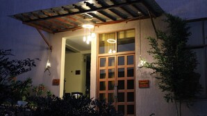 A building with a large wooden door and multiple hanging lights.