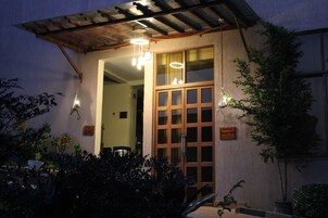 Un edificio con una puerta de madera grande y varias luces colgantes.