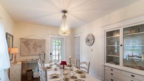 Comedor con candelabro, mapa mundial y un reloj en la pared.