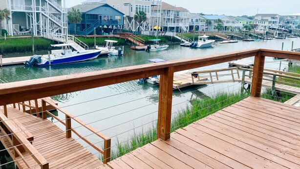 Una marina con barche ormeggiate, passerelle in legno e edifici sul lungomare.