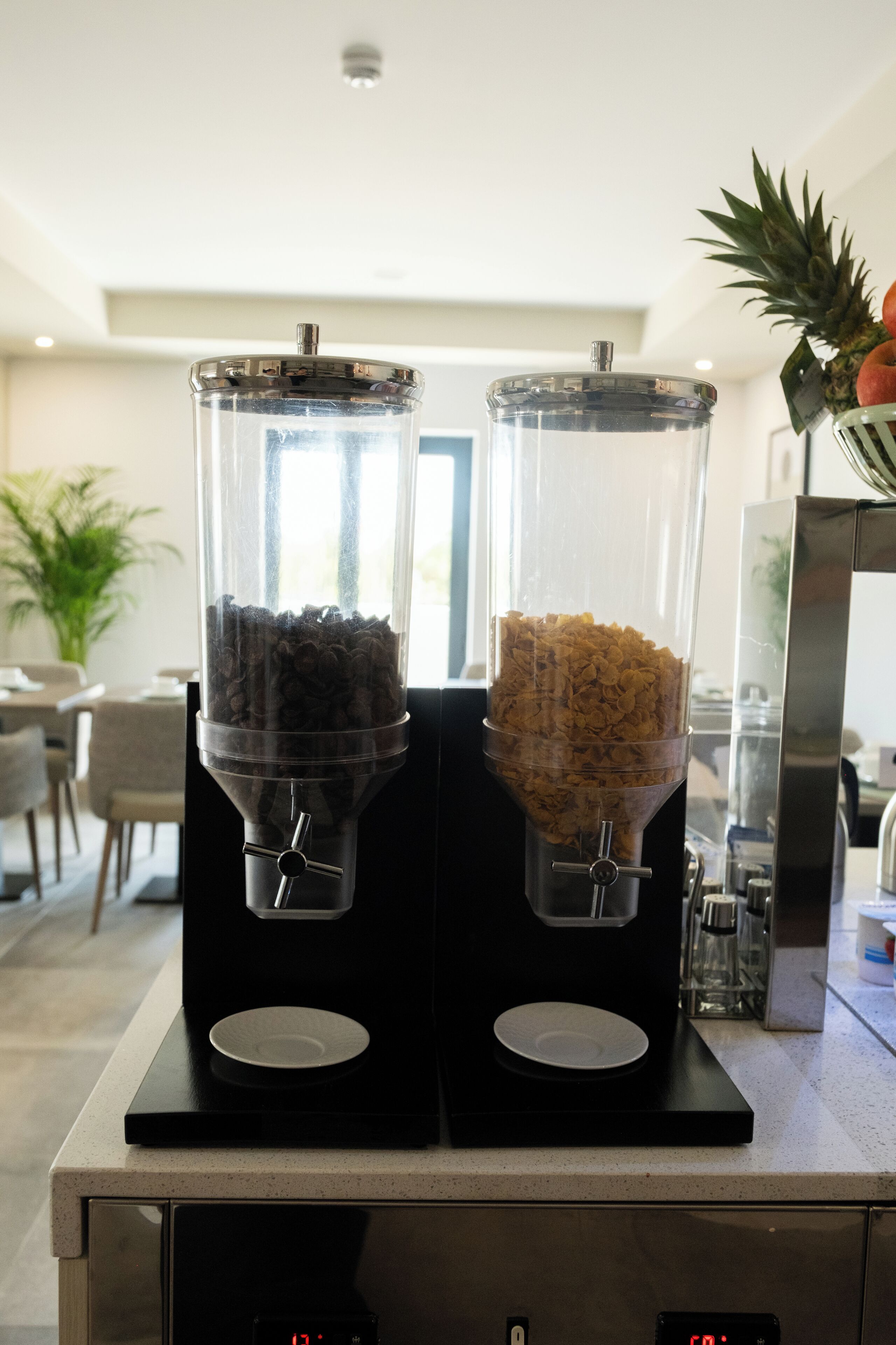 Eine Kaffeemaschine mit zwei Behältern, einer für Kaffeebohnen und der andere für gemahlenen Kaffee, in einer modernen Kücheneinrichtung.