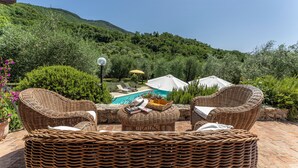 A patio with wicker furniture, a pool, and umbrellas. - Fienile di Fabio by Geco Vacation Rentals (Vaiano)