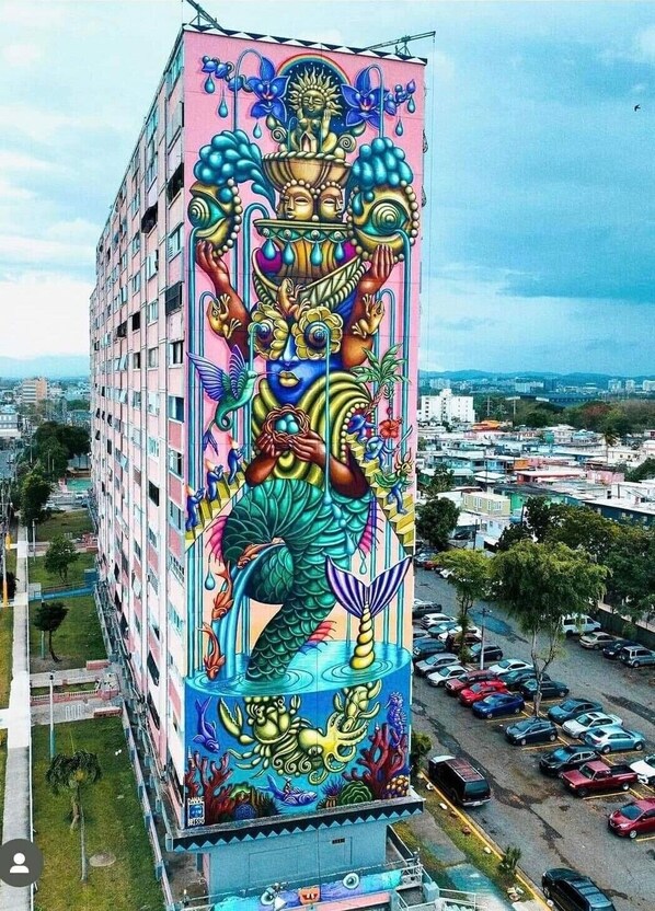 A tall building with a vibrant mural featuring a mermaid and other sea creatures.