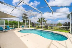 A covered swimming pool with lounge chairs and a clear view of the surrounding landscape. - Unique comfortable Golf course Home w Private Pool (Davenport)