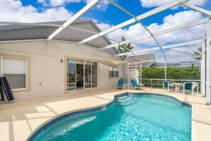 A swimming pool with a glass enclosure, a covered patio area, and a view of the surrounding landscape. - Unique comfortable Golf course Home w Private Pool (Davenport)