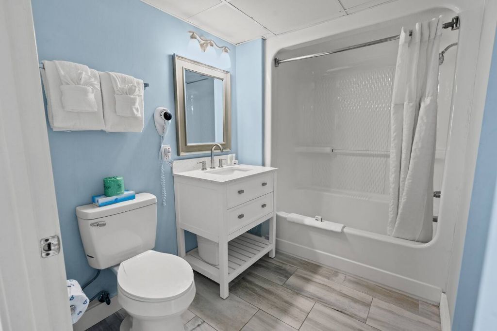 Un baño con inodoro, lavamanos y ducha.