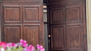 A large wooden double door with a decorative design, set within an arched doorway. - La Casa di Cri (Asti)