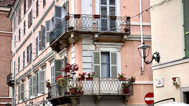 A street with a row of buildings, some with balconies and outdoor seating. - La Casa di Cri (Asti)