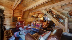 Interior acolhedor de uma cabana de madeira com quarto no mezanino, paredes de madeira e um tapete xadrez.