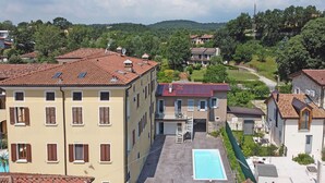 A residential area with a swimming pool, terraced houses, and a hillside in the background. - San Carlo Borromeo 1 by Wonderful Italy (Soiano del Lago)