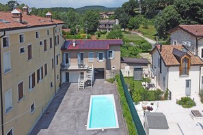 A residential building with a swimming pool, multiple balconies, and a staircase leading to the entrance. - San Carlo Borromeo 1 by Wonderful Italy (Soiano del Lago)