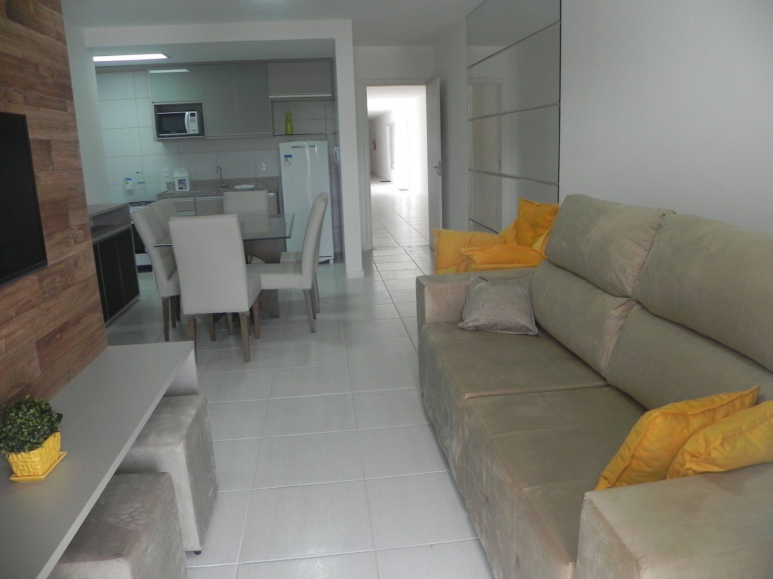 A modern living room with a sofa, chairs, and a dining table.