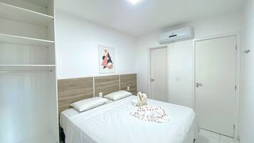 A bedroom with a bed, a wardrobe, a door, and a ceiling light.