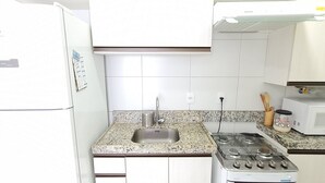 A kitchen with a refrigerator, sink, stove, and microwave. - Flats no Muro Alto Condomínio Club (Ipojuca)