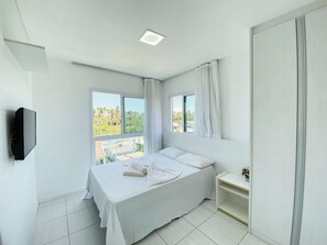Relax in this serene bedroom with a large bed, flat-screen TV, and stunning views of the surrounding greenery.