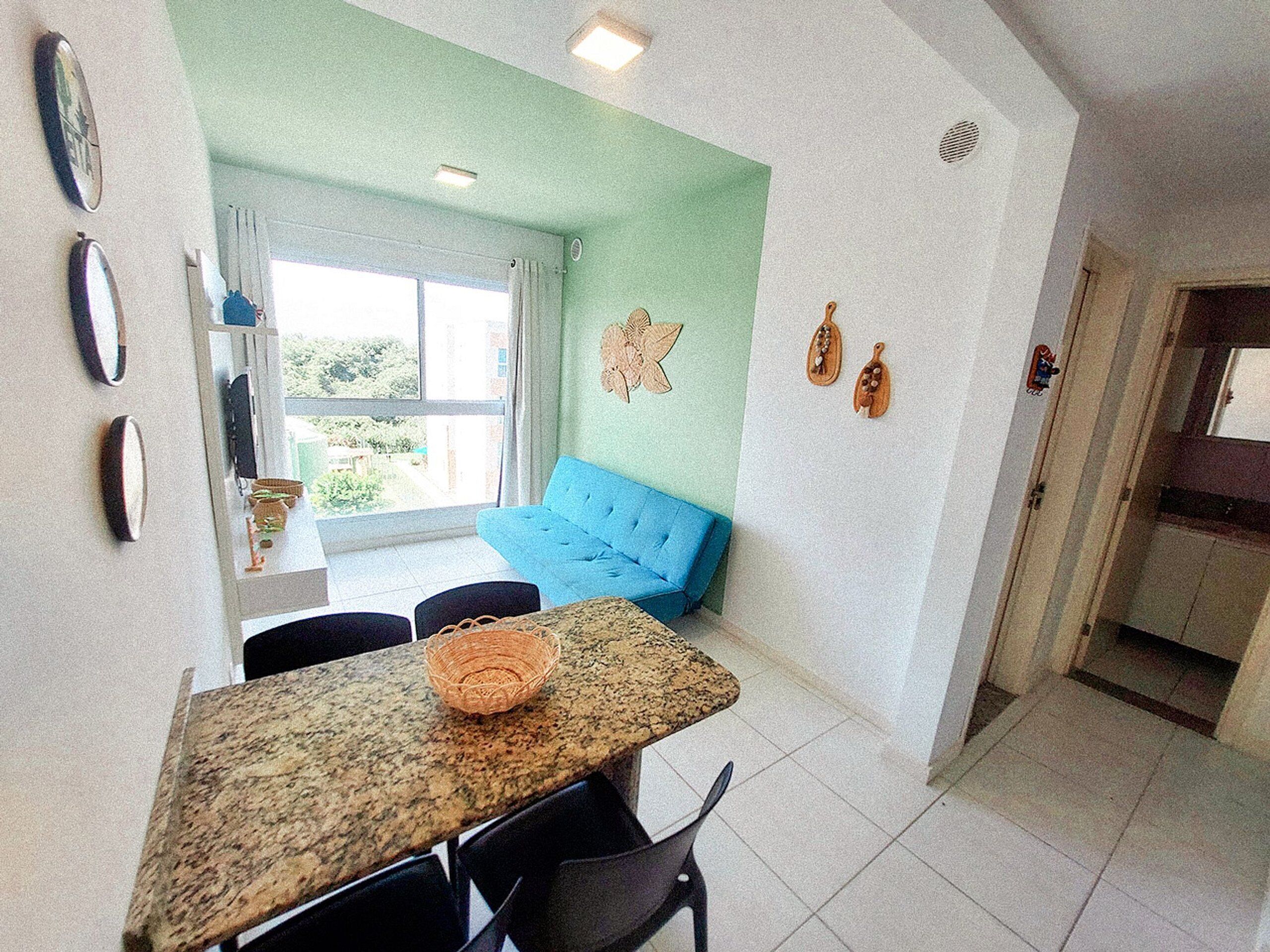 A dining area with a table, chairs, and a blue sofa.