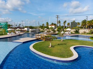 Relax by the pool surrounded by lounge chairs, umbrellas, and lush greenery.