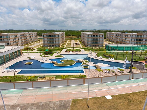 Relax by the pool surrounded by lush greenery and lounge chairs.