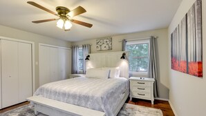 A bedroom with a bed, bedside tables, a ceiling fan, and artwork on the walls. - Lakefront Hot Springs Vacation Rental w/ Dock! (Hot Springs)