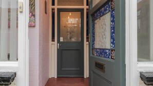 A door with a frosted glass panel, a small window with a floral design, and a light fixture above. - 50 West Street Edelweiss (Scarborough)