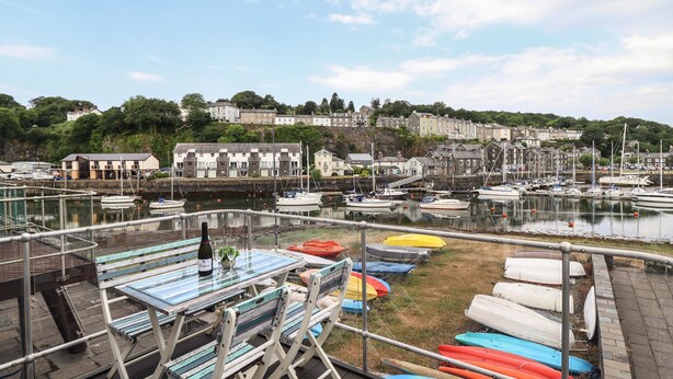 A marina with boats and a table with chairs.