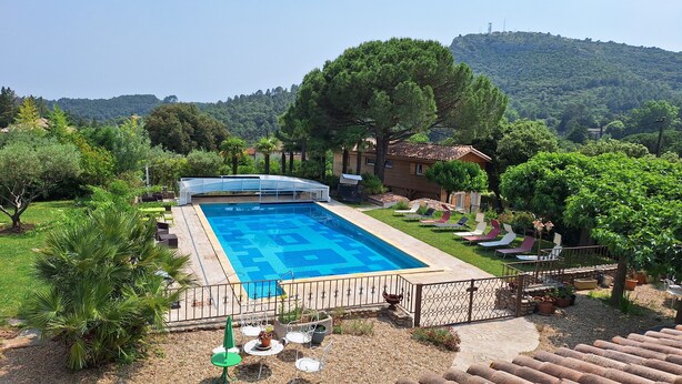 A swimming pool with a deck, surrounded by greenery and a view of hills. - A l'ombre du chêne : Gîte Éden en Cévennes swimming pool, calm & nature at Anduze (Anduze)